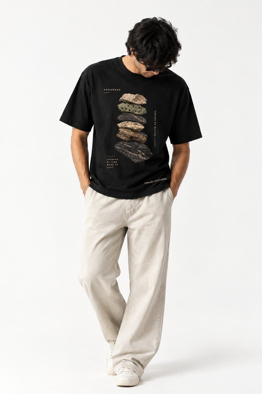 Model looking down, wearing Layers of Earth TN01 in an oversized fit