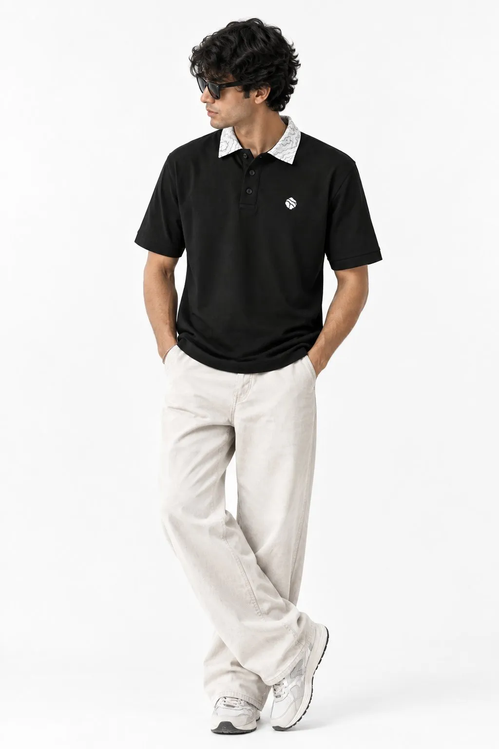 Model wearing the black Land Form polo with off-white trousers