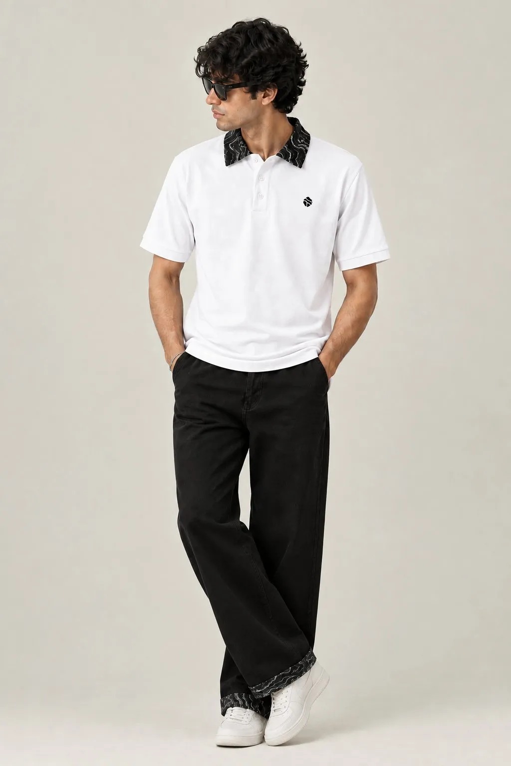 Model wearing the white Land Form polo with black trousers
